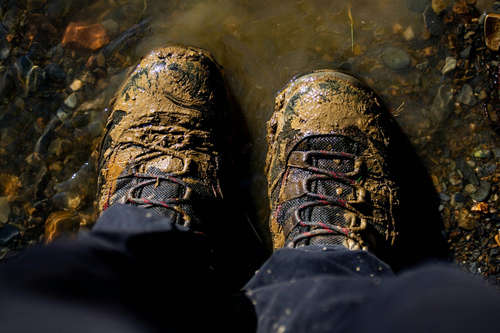a pair of feet standing in a stream of water