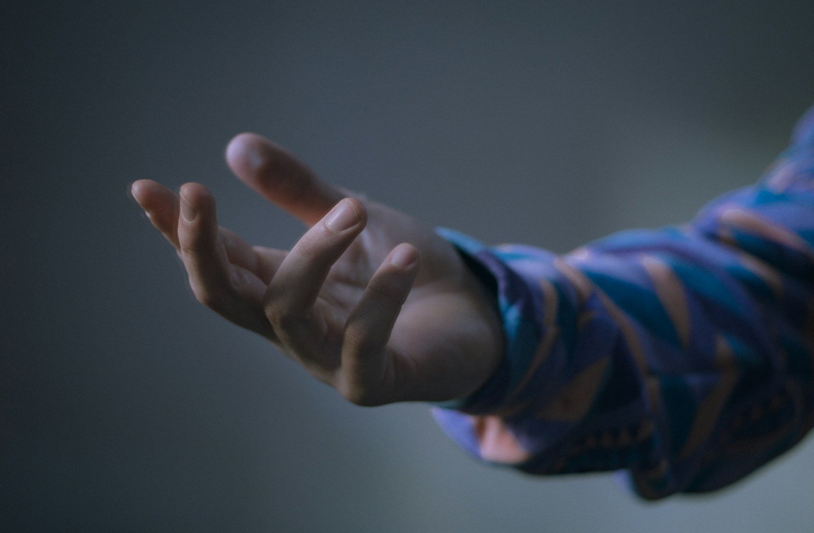 A person's outstretched hand reaching forward.