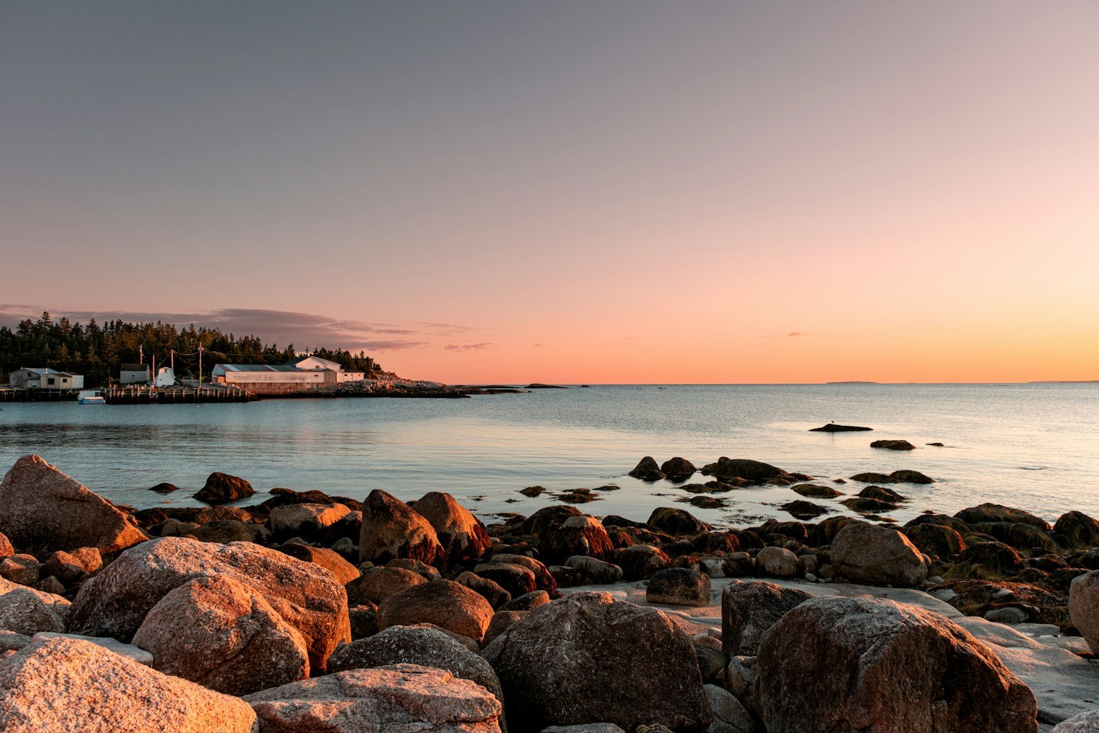 Rocky coastline at sunset with calm ocean waters